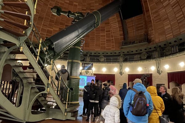 People in a dome next to a telescope