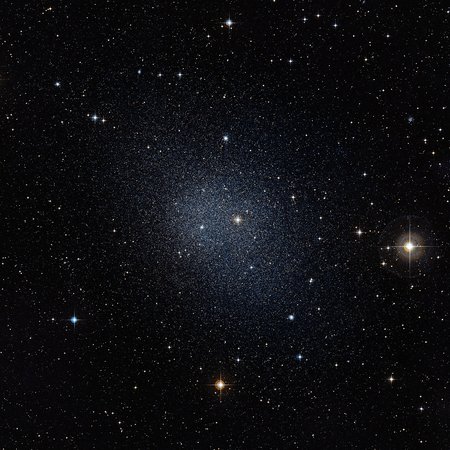 Dark sky with a brighter spot in the centre, which consists of many stars